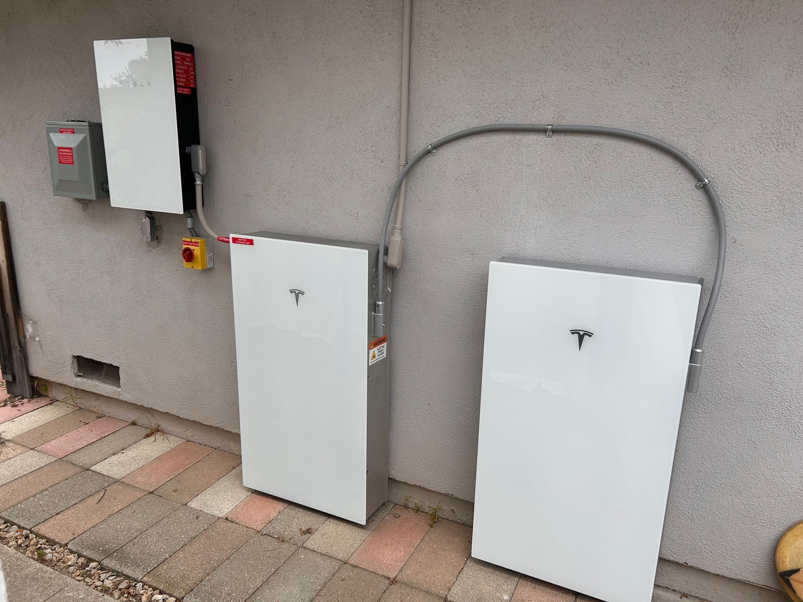 Two Tesla Powerwall 3 units installed on an exterior wall with Backup Gateway and shutoff, Ventura County